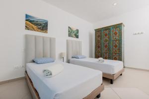 deux lits dans une chambre aux murs blancs dans l'établissement Best Riviera Maya Penthouses&Apartments, à Playa del Carmen 32 autres photos