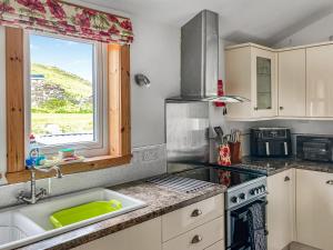 una cocina con fregadero y ventana en Sandwoodway, en Rhiconich