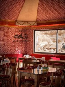 a restaurant with tables and chairs and a window at RUM DESERT BREEZE lUXURY CAMP in Wadi Rum