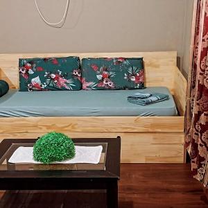 a wooden bed with a table and a plant on it at Serendipia in Oberá