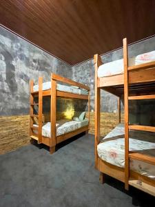 Ce lit se trouve dans un dortoir doté de 2 lits superposés et d'un mur. dans l'établissement Ijen Backpacker Atas Angin dekat Stasiun Banyuwangi Kota, à Giri