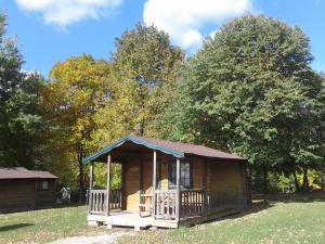 a small wooden cabin in a field with trees at Fremont RV Campground Cabin 8 in Fremont