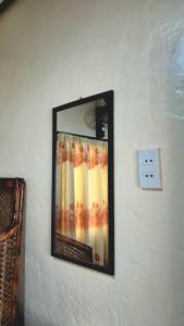 a mirror hanging on a wall next to a lightswitch at Charity Pension House in San Vicente