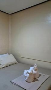 a pair of shoes sitting on top of a bed at Charity Pension House in San Vicente