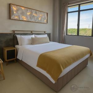 a bedroom with a large white bed and a window at Irama Kopa - Glory Beach Resort in Port Dickson