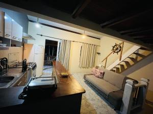 a large living room with a couch and a kitchen at Chalé em ilhabela in Ilhabela
