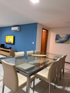 a dining room with a glass table and chairs at Apartamento Térreo no Catu Lake Resort Aquiraz in Aquiraz