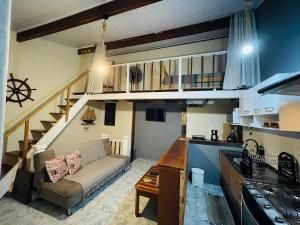 a living room with a couch and a staircase at Chalé em ilhabela in Ilhabela +7 photos