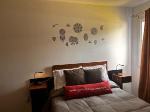 Un dormitorio con una cama con una almohada roja encima. en La golondrina, en La Falda 35 fotos más