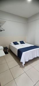 a bedroom with a bed in a white room at Exclusive space in the Center, affordable accommodation in Castanhal