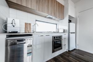 a kitchen with stainless steel appliances and wooden cabinets at The Inner-North Escape - Free Parking & Wifi in Melbourne