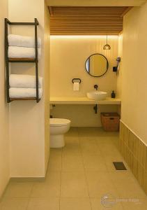 ein Badezimmer mit Toilette, Waschbecken und Spiegel in der Unterkunft Irama Kopa - Glory Beach Resort in Port Dickson