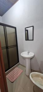 a white bathroom with a sink and a shower at cabinas langosta feliz in Savegre +10 photos