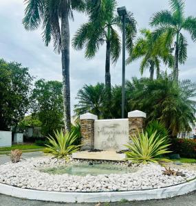 a fountain in a park with palm trees at Burungos Place at Humacao, PR in Humacao