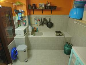 eine kleine Küche mit Spüle und Mikrowelle in der Unterkunft Meechok Home in Chiang Mai + 60 Fotos