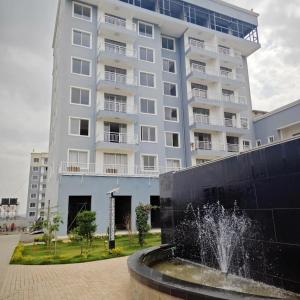 a large white building with a fountain in front of it at Chichi homes sabaki green estate in Nairobi