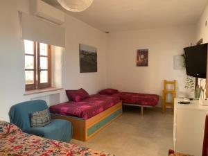 Una habitación con una cama, un sofá y un televisor. en El Oasis de los Jarales, en Almayate Alto