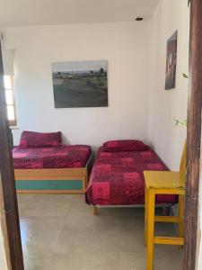 2 camas en una habitación con mesa y escritorio en El Oasis de los Jarales, en Almayate Alto