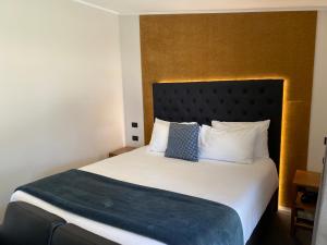 ein Schlafzimmer mit einem großen weißen Bett mit einer blauen Decke in der Unterkunft Kennedy Park Resort Napier in Napier