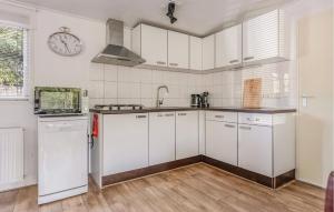 a kitchen with white cabinets and a clock on the wall at Beautiful Home In Erm With Wifi in Erm