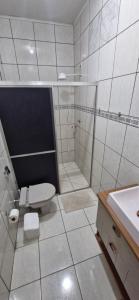 a bathroom with a shower and a toilet and a sink at Apartamento central completo in Tangara da Serra +12 photos