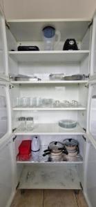 a refrigerator filled with lots of dishes and pans at Apartamento central completo in Tangara da Serra