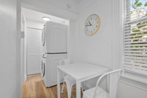 a kitchen with a refrigerator and a table and a clock at Pittsburgh Shadyside 2D Modern and Stylish Private Bedroom with Shared Bathroom in Pittsburgh