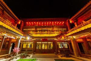 Un gran edificio con luces rojas por la noche. en Zhifang Hotel, en Datong
