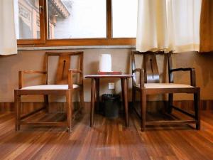 two chairs and a table in a room with a window at Zhifang Hotel in Datong