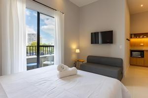 une chambre avec un grand lit blanc et un canapé dans l'établissement Studio completo na Vila Mariana!, à São Paulo 161 autres photos