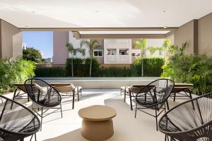 un patio avec chaises et tables et une piscine dans l'établissement Studio completo na Vila Mariana!, à São Paulo