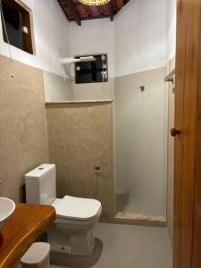 a bathroom with a toilet and a sink and a shower at Pousada Casarão - Pé na Areia Cumuruxatiba in Cumuruxatiba
