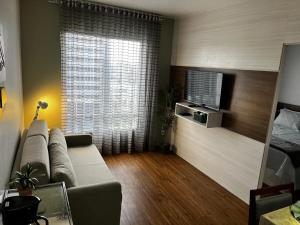 a living room with a couch and a large window at Flat dentro de hotel de Luxo proximo ao shopping in Manaus +41 photos