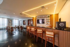 a restaurant with a bar with tables and chairs at Flat dentro de hotel de Luxo proximo ao shopping in Manaus