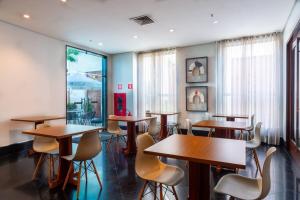 a restaurant with tables and chairs in a room at Flat dentro de hotel de Luxo proximo ao shopping in Manaus