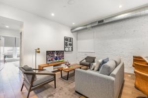 a living room with a couch and a brick wall at The Saddlery-Frequency-2 Units-Walk 2 Broadway in Nashville