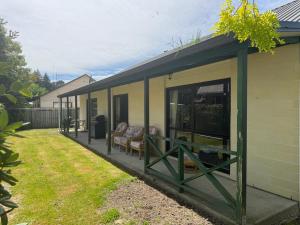 a house with a porch with a couch and chairs at 8b Rippingale Road in Hanmer Springs