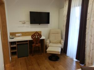 a room with a desk and a chair and a television at Penzion Tavcar in Ljubljana