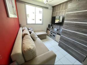 ein Wohnzimmer mit Sofa und Fernseher in der Unterkunft Hospedagem Apto Residencial Canela in Canela