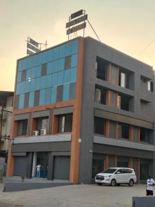 a building with a car parked in front of it at Hotel Royal Park Rooms in Vapi