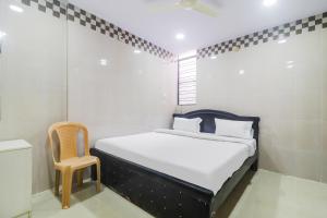 ハイデラバードにあるHotel O Aroma Classic Near Nampally Railway stationのベッドと椅子のある小さな寝室 +65枚の写真