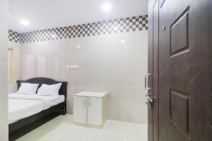 a small bedroom with a bed and a door at Hotel O Aroma Classic Near Nampally Railway station in Hyderabad