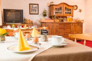 una sala da pranzo con tavolo e cappelli da festa di Gästehaus Schmid a Obermaiselstein