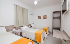 a hotel room with two beds and a window at Hotel Araçari in Araçariguama