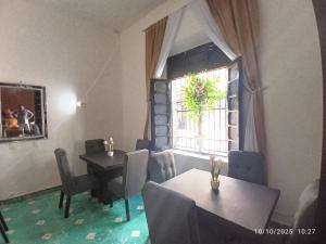 a dining room with a table and a window at posada ah mun centro in Mérida