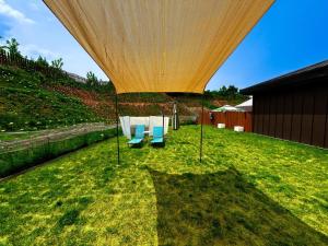 a patio with two chairs and a table in the grass at Dangjin Dogpelis Glamping in Dangjin