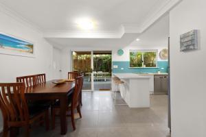 a kitchen and dining room with a table and chairs at Shivas Byron - 2 - 3 Somerset Street in Byron Bay +3 photos