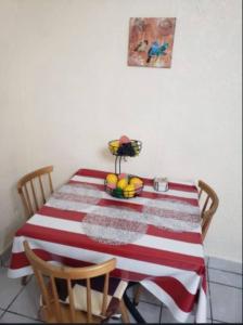 Una mesa roja y blanca con un bol de fruta encima. en AlegreA -2 br apartment with secure parking included, en Playas de Rosarito