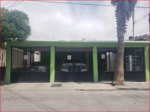 Un edificio verde con un coche dentro. en AlegreA -2 br apartment with secure parking included, en Playas de Rosarito 2 fotos más