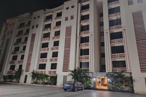 une voiture garée devant un immeuble la nuit dans l'établissement Collection O Reeva Regency, à Shirdi